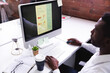 © Wavebreak Media - African american man using computer while sitting on his desk at modern office