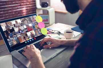 Poster - Caucasian man siting at desk, using laptop, having video call with coworkers