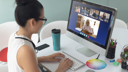 Sticker - Asian woman sitting at desk having video call with coworkers