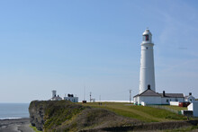 Nash Point Lighthouse In The Vale Of Glamorgan, Wales With A Blue Sky On A Sunny Spring Day