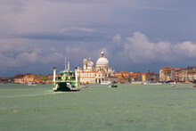 Cathedral Of Santa Maria Della Salute (Basilica Di Santa Maria Della Salute). Venice, Italy. Stormy Sky, Dark Clouds, The Tug Comes To The Pier.