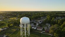 Aerial Orbit Of A Water Tower In Suburban Clarksville, Tennessee, Revealing A Beautiful Sunset At The End