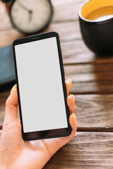 Sticker - Unrecognizable woman uses a smartphone while having breakfast. Device screen is blank for use with mock up or copy space.