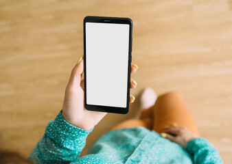 Sticker - An unrecognizable woman stands and holds a smartphone with one hand. Gadget screen is blank, for using mock up or copy space.