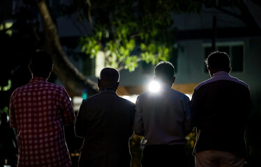 worship of the Allah's kindness by four middle age man in the garden at night time