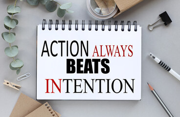 Action Always Beats Intention. text on white paper on gray background