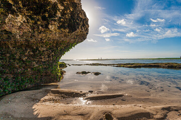 Wall Mural - Picture of a natural beach in Bali with a big rock in the sunlight