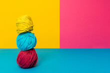 Pile Of Assorted Soft Woolen Thread Balls In Pile On Yellow And Pink Background