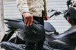 © David Munoz/ADDICTIVE STOCK - Side view of crop anonymous male motorcyclist with protective helmet standing against modern motorbike in town