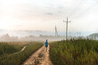 © GALDRIC.COM/ADDICTIVE STOCK - Back view of unrecognizable male runner jogging along sandy path in countryside during training in foggy morning in summer