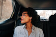© Jake Jakab/ADDICTIVE STOCK - Carefree young African American female with TWS earbuds listening to music in modern automobile looking out the windows