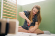 © Jake Jakab/ADDICTIVE STOCK - Young expectant female using screwdriver while assembling baby cot and sitting on floor at home