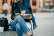 © Jake Jakab/ADDICTIVE STOCK - Crop Muslim female in hijab writing in diary while sitting on city street and looking away