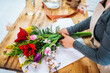 © jordi sark/ADDICTIVE STOCK - From above cropped unrecognizable female florist in casual clothes and apron arranging elegant bouquet of assorted flowers in store
