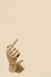 © Jose Lax/ADDICTIVE STOCK - High angle of wooden hand with index finger pointing up on beige background in studio