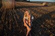 © Laura Bauza/ADDICTIVE STOCK - Peaceful female in elegant dress sitting on dry field in rural area and looking at camera