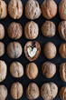 © Leire Gamboa/ADDICTIVE STOCK - Top view of textured backdrop representing heart shaped walnut center among whole nuts with uneven nutshells