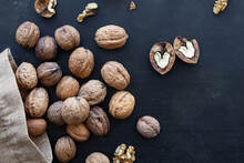 From Above Bag With Whole And Halved Walnuts With Dry Nutshells And Heart Shaped Center On Table