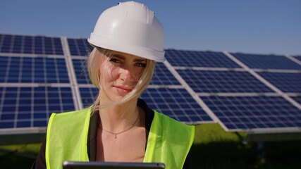 Close up portrait of young beautiful woman in protective helmet. Female engineer looking at camera and smiles