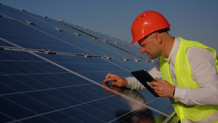 Caucasian man technician using laptop computer checking Solar Cell panels. Engineer repair and maintenance photovoltaic