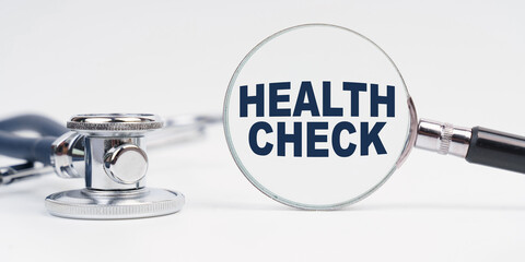 There is a stethoscope on the table, a magnifying glass with the inscription - HEALTH CHECK