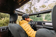 © Marcos Osorio/ADDICTIVE STOCK - From behind inside view of a driver wearing a cap and sunglasses in an off-road car looking away