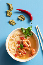 Tom Yum Soup In Bowl With Chopsticks On Blue Background