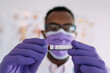 © Sergio Victor Vega/ADDICTIVE STOCK - African American male doctor in medical glove demonstrating test tube with blood sample on white background
