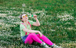 © Sergio Victor Vega/ADDICTIVE STOCK - Expressive young female in bright colorful clothes playing with soap bubbles and sitting on verdant green meadow in nature