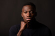 © Shey Nunez/ADDICTIVE STOCK - Confident young African American guy in black clothes with hand at chin looking at camera on black background in light studio