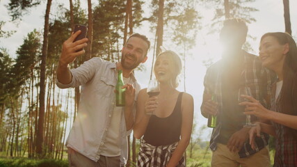 Wall Mural - Smiling friends sending greetings on camera outside. Guys having video call