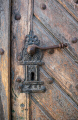 Old wooden door with a metal wrought iron lock. Castle, fortress 