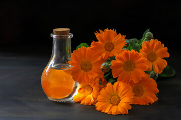 Wall Mural - Aromatherapy essential oil with marigold flowers - Calendula officinalis

