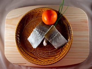 Wall Mural - Top view of slightly salted raw fish fillets with green onion and tomato on a plate