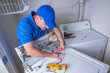 © spatesphoto - Appliance repair service on a top load washing machine