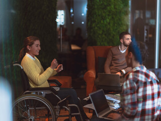 Wall Mural - Businesswoman in wheelchair having business meeting with team at modern office 