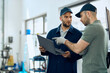© Drazen - Two mechanics cooperating while working on laptop at auto repair shop.