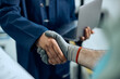 © Drazen - Close-up of auto repair manager and mechanic shaking hands in a workshop.