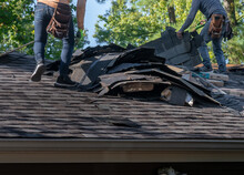 Roofers Removing Old Material From A House In Preparation For Storm Damage Repair.	