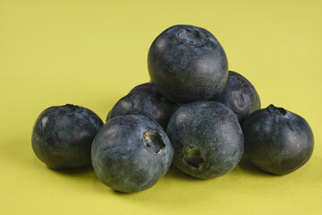 Wall Mural - Heap of blueberries on yellow background