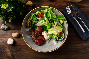 Grilled steak with green lettuce, cucumber and fresh rosemary. Home made tasty food. Concept for a tasty and healthy meal. fresh salad with grilled beef