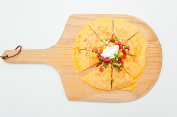 Wall Mural - Top view of a tasty pizza with vegetables and white sauce in the middle on a wooden food board