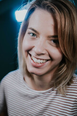 Wall Mural - Portrait of a blonde short-haired Caucasian woman with blue eyes smiling at the camera