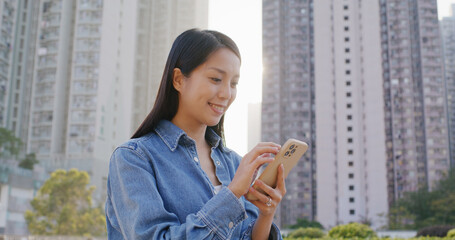 Wall Mural - Woman use of smart phone under sunlight