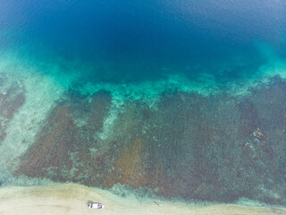 Aerial shot of islands washed by blue ocean water in Indonesia