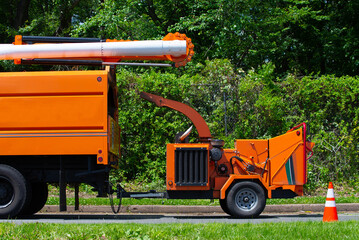 Wood chipper machine releasing the shredded woods into a truck tree work