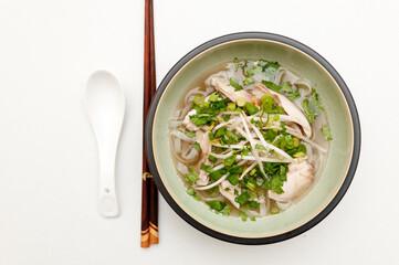 Poster - Top view of Vietnamese pho soup with a spoon and Chinese wooden sticks isolated on a white surface