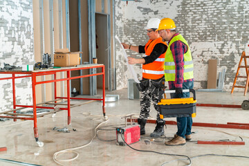 Adult construction workers working on housing plan while at construction site