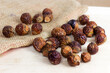 Brown dry soap nuts (Soapberries, Sapindus Mukorossi) for organic laundry and gentle natural skin care on light background.
