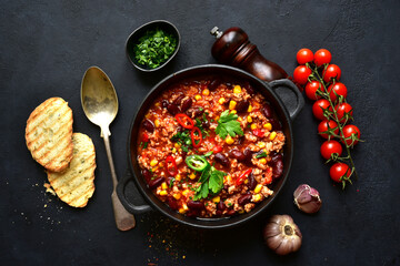 Wall Mural - Chili con carne - traditional mexican minced meat and vegetables stew in tomato sauce in a cast iron pan . Top view with copy space.